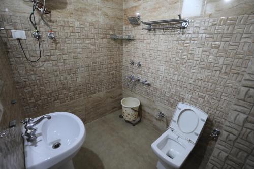a bathroom with a toilet and a sink at Mahadev Hotel and Resorts in Katra