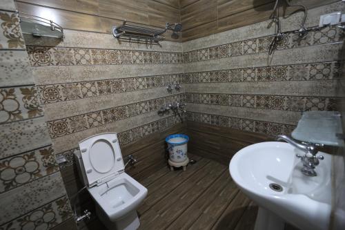a bathroom with a toilet and a sink at Mahadev Hotel and Resorts in Katra