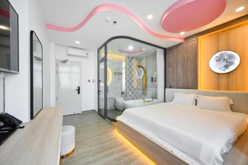a bedroom with a large bed and a bathroom at Lotus Airport Hotel Saigon in Ho Chi Minh City
