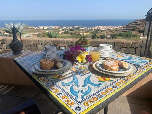 a table with food on it with a view of the ocean at Mina' Alfarah in Pantelleria