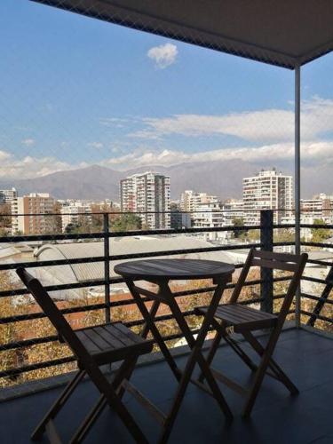 a table and two chairs on a balcony with a view at Dpto Pedro de Valdivia, cercano a Costanera Center in Santiago
