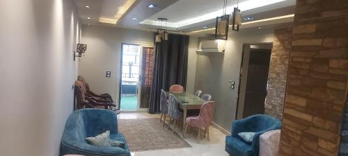 a living room with blue chairs and a table at Gardinia City luxury Home with 3bed rooms and private pool in Cairo