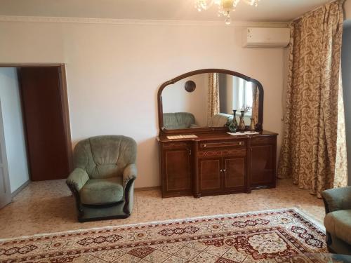 a living room with a chair and a mirror at Apartment Shevchenko Panfilova in Almaty