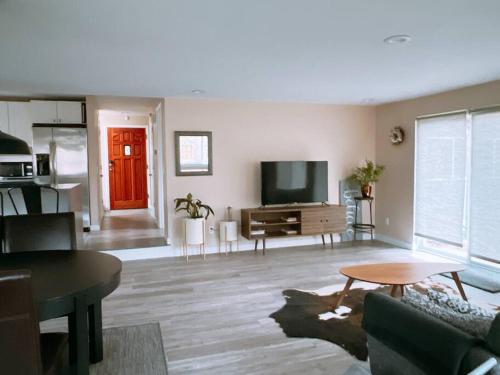 a living room with a couch and a tv at Livable D near Lake Washington in Lake Forest Park