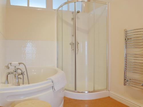 Little Burcott Loft في Wookey: حمام أبيض مع دش وحوض استحمام