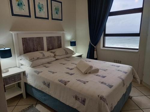 ein Schlafzimmer mit einem Bett mit Blick auf das Meer in der Unterkunft South Coast Riviera - 805 in Port Shepstone