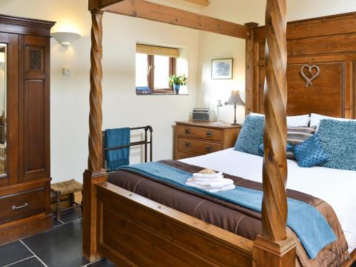 a bedroom with a four poster bed and a desk at The Linhay in Milford