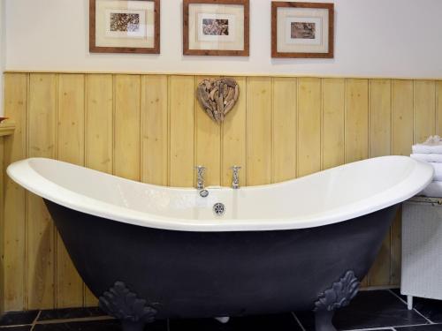 a bath tub in a bathroom with wooden walls at The Linhay in Milford