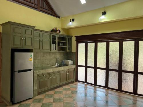 a kitchen with a white refrigerator in a room at บ้านทรายแก้ว 129HOUSE in Klaeng