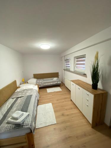 1 dormitorio con 2 camas y suelo de madera en 44 Śląska en Kamienna Góra
