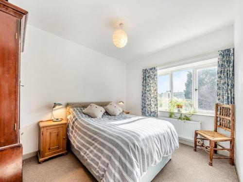 a bedroom with a bed and a chair and a window at 4 Cromwells Cottage-uk40933 in Pembroke