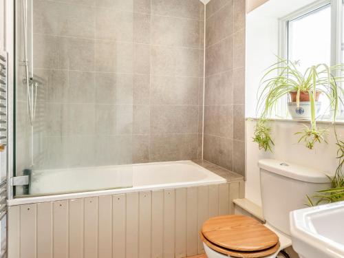 a bathroom with a tub and a toilet and a sink at 4 Cromwells Cottage-uk40933 in Pembroke