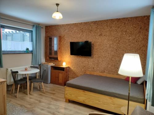 シュクラルスカ・ポレンバにあるStajniaのベッド、テーブル、テレビが備わる小さな客室です。