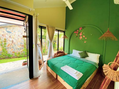 a green bedroom with a bed and a window at Bến Đò Xưa Homestay & Coffee in Cái Răng