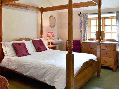 a bedroom with a canopy bed and a sink at Brothersfield Cottage in Patterdale