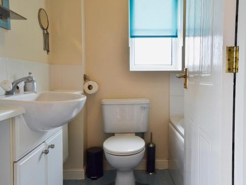a bathroom with a white toilet and a sink at Marina View in East Cowes