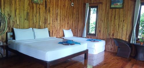 a bedroom with two beds in a room with wooden walls at Kohjum Freedom Resort in Ko Jum