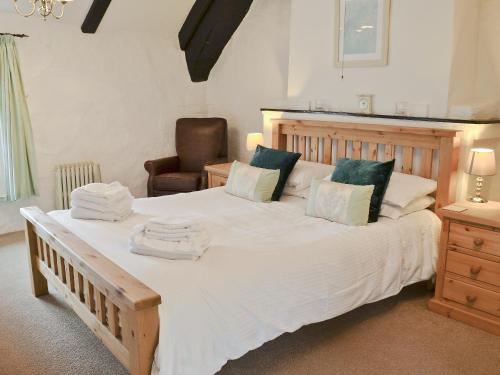 1 dormitorio con 1 cama grande y toallas. en Bee Bowl Cottage - Httd, en Bideford