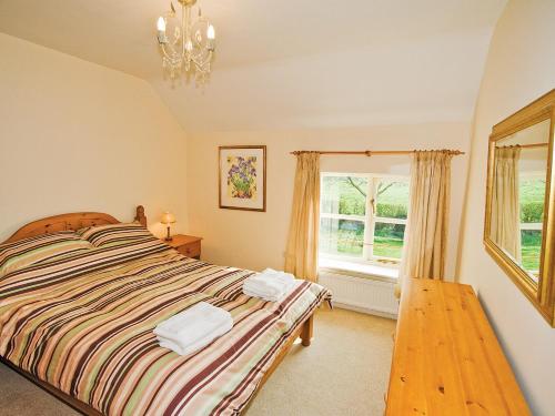 a bedroom with a bed and a window at Brook House Farm Cottage in Church Minshull