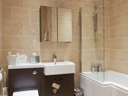 ein Badezimmer mit einem Waschbecken, einer Dusche und einer Badewanne in der Unterkunft One The Old Stables in Knitsley