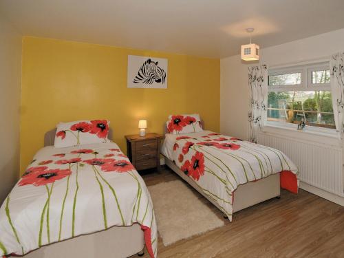 a bedroom with two beds and a window at Hidden Garden Cottage - E5543 in Wainfleet All Saints