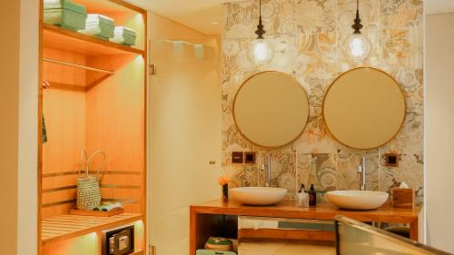 a bathroom with two sinks and two mirrors on the wall at Annora Villas Seminyak in Seminyak