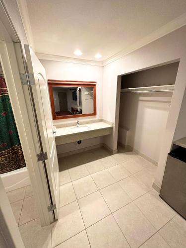 a bathroom with a sink and a television in it at Tropic West Motel in Bell