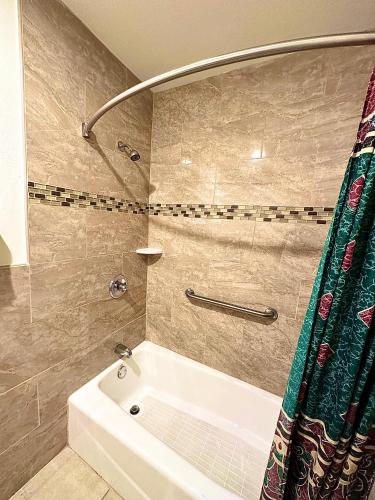 Bell的住宿－Tropic West Motel，浴室配有白色浴缸和淋浴。