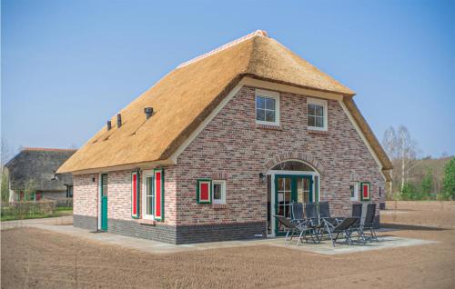 a small house with a thatched roof and chairs at 4 Bedroom Gorgeous Home In Den Ham in Den Ham