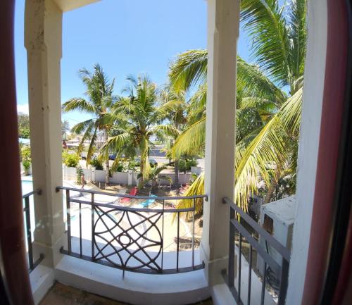 uitzicht vanaf het balkon van een resort met palmbomen bij Residence Abrico in Mont Choisy