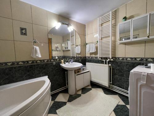a bathroom with a sink and a toilet and a tub at Ada-Ini House in Craiova