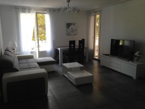 un salon avec un canapé et une télévision dans l'établissement T3 centre de Cassis parking, climatisé, wifi, à Cassis