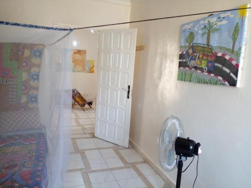 a room with a white door and a fan at Auberge Triskell in Nouakchott