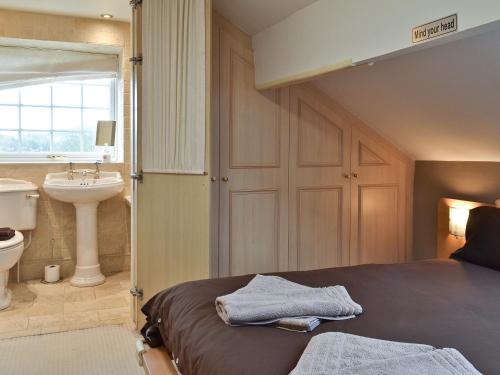 1 dormitorio con cama, lavabo y aseo en Ellers Bank en Hayfield