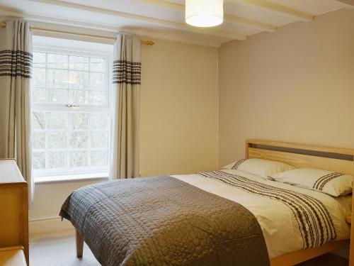 a bedroom with a bed and a large window at Ellers Bank in Hayfield