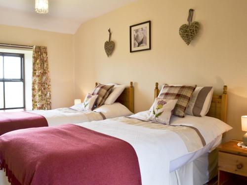 two beds in a room with hearts on the wall at Addyfield Farmhouse - 14512 in Bowland Bridge