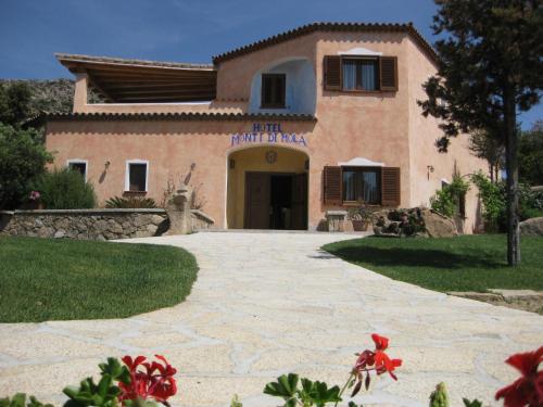 a large white building with a large window at Hotel Monti Di Mola in Porto Cervo
