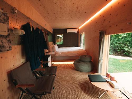 a bedroom with a bed and a desk with a chair at SNOW PEAK FIELD SUITE SPA HEADQUARTERS in Morimachi