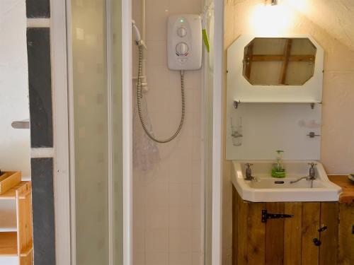 a small bathroom with a sink and a shower at The Workshop - 27716 in Tipton Saint John