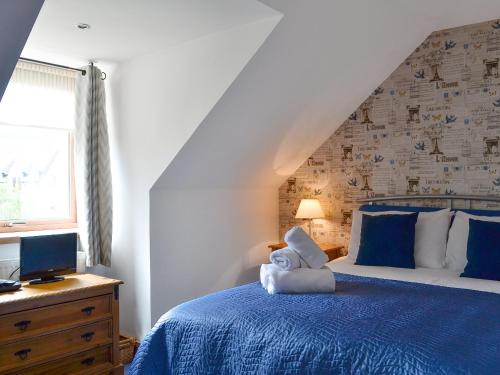 um quarto com uma cama azul com um ursinho de peluche em Coire Cas - S4538 em Aviemore
