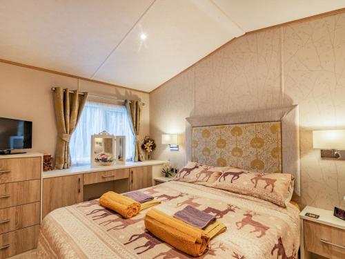 a bedroom with a large bed and a television at Woodlands in Sewerby