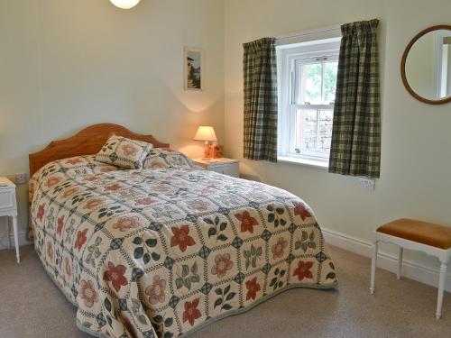 1 dormitorio con cama y ventana en Berrymoor Farm Cott, en Kirkoswald