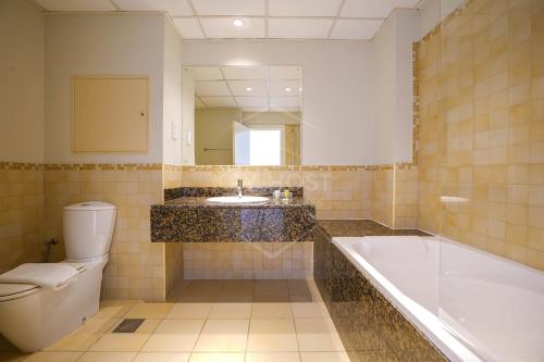 a bathroom with a tub and a toilet and a sink at KeyHost - Full Sea View Majestic 2BR Apartment - Rimal JBR - K2530 in Dubai