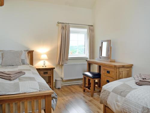 a bedroom with two beds and a desk and a window at Nice Home In Wales W- in Strata Florida