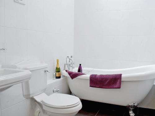 La salle de bains est pourvue de toilettes, d'un lavabo et d'une baignoire. dans l'établissement Nice Home In Wales W-, à Strata Florida