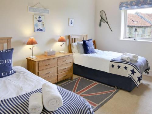 a bedroom with two beds and a window at Tweedmouth Cottage in Scarborough