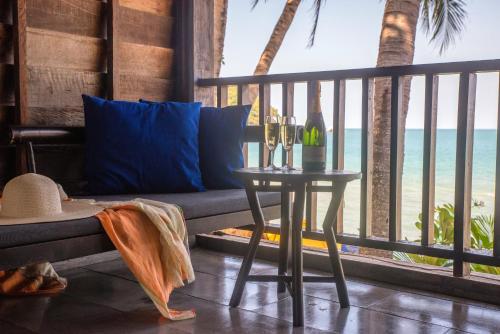 a living room with a table and a view of the ocean at Buri Rasa Village Phangan in Thong Nai Pan Noi