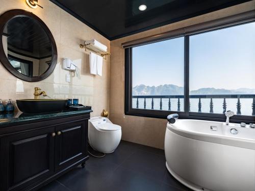 ein Bad mit einer Badewanne, einem Waschbecken und einem Fenster in der Unterkunft Rita Cruise in Hạ Long