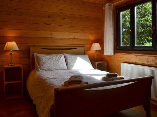 Churn - Uk12536 في Witheridge: غرفة نوم مع سرير في كابينة خشب