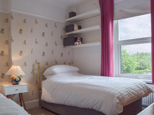 a bedroom with a bed and a window at Middleton Cottage in Llanddarog